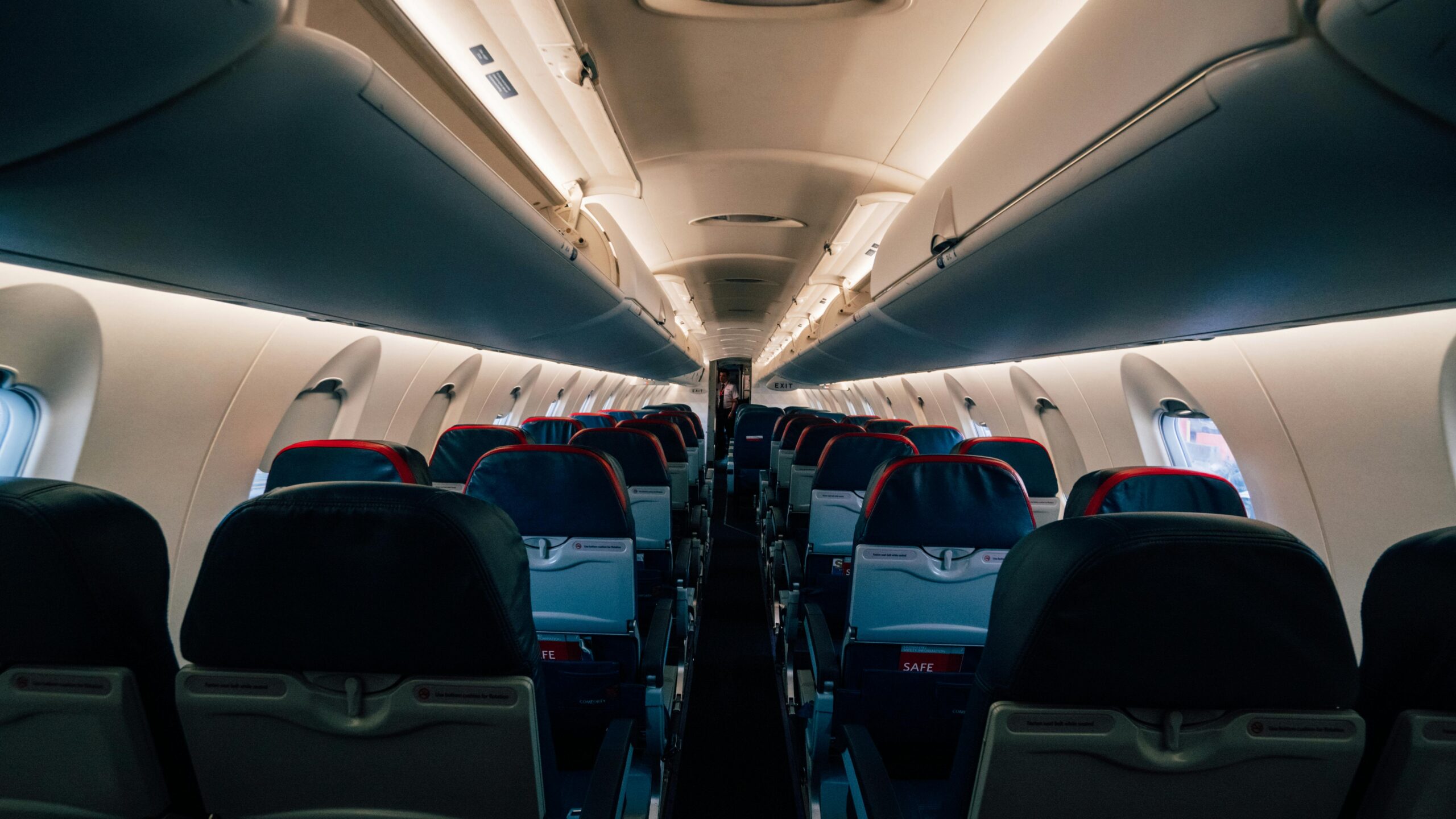 Interior view of an empty airplane cabin featuring modern rowed seating.